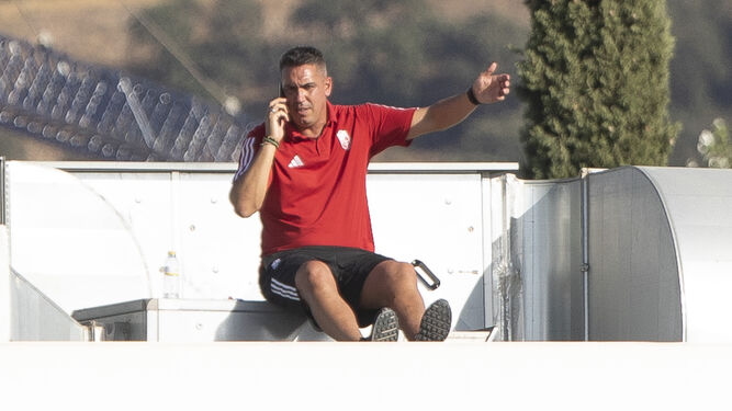 Juan Antonio Milla indicando con el teléfono en el tejado de las instalaciones del Granada