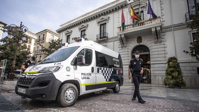Imagen de archivo de un furgón de la Policía Local y un agente en el Ayuntamiento de Granada