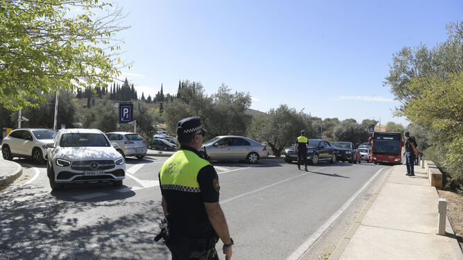 Agente de la Local regula el tráfico en el parking del cementerio de Granada, en una imagen de archivo.
