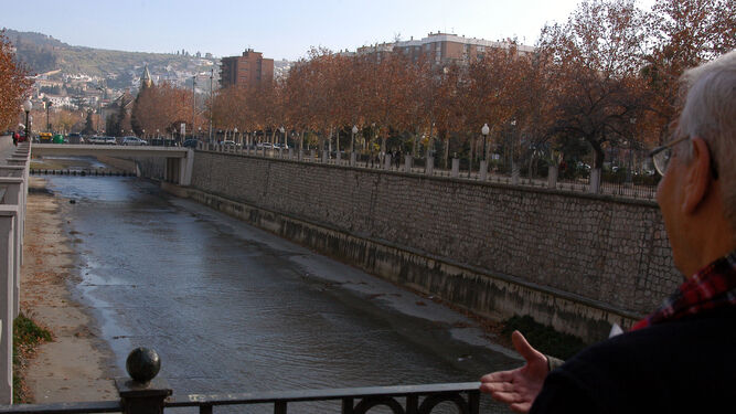 Un hombre mira hacia el centro de Granada desde el Río Genil