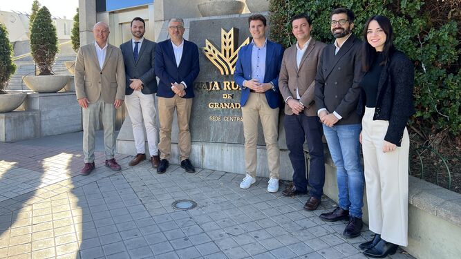 Miembros de Caja Rural y AJE ante la sede de la institución financiera.