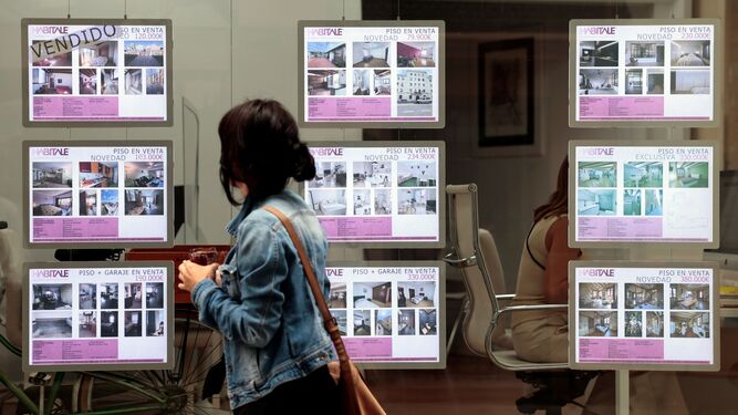 Una mujer se fija en unos anuncios de una inmobiliaria en una imagen de archivo.
