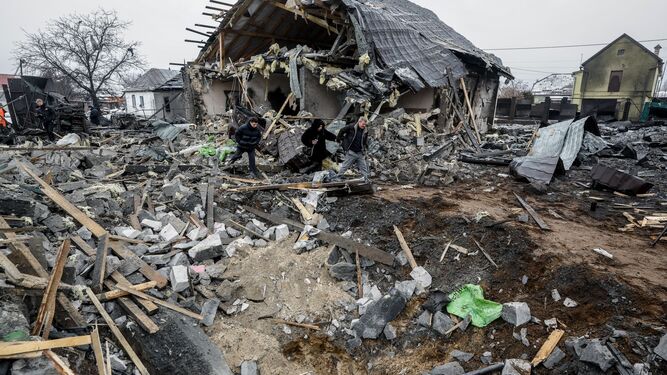 Residentes caminan junto a una casa destrozada por un misil ruso en Kiev.