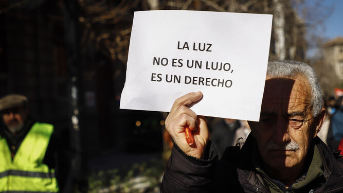 Imagen de archivo de un hombre con un cartel participando en una manifestación convocada por la Plataforma Contra Los Cortes de Luz por el centro de Granada contra los cortes de luz.