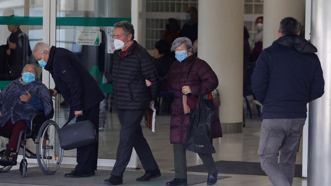 Varias personas con mascarilla a las puertas del Hospital Virgen del Rocío.