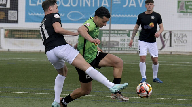 El jugador del Huétor Vega defiende la posesión frente al Málaga City