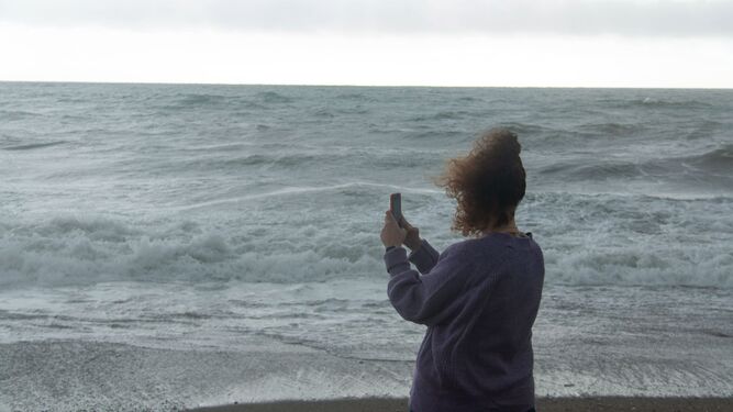 Mujer fotografiando el mar en la costa de Granada