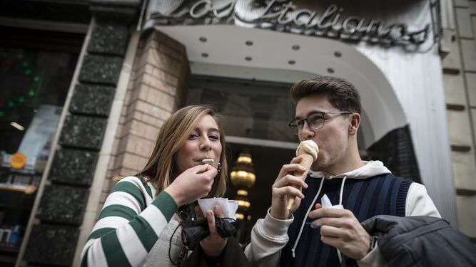 Dos jóvenes disfrutan de unos helados a las puertas del local.
