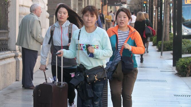 Unas turistas caminan por las calles de Granada con sus maletas