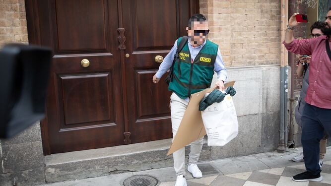Un agente de la UCO de la Guardia Civil sale de la casa de Rubiales en Granada con documentación tras el registro