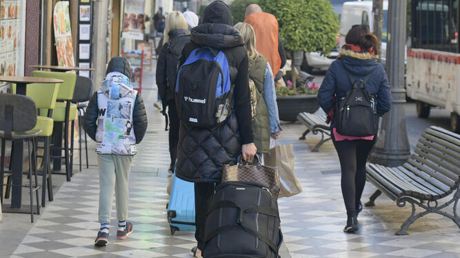 Un hombre camina por el centro de Granada con maletas