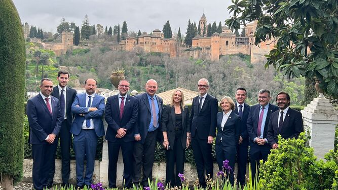 Autoridades políticas locales y autonómicas junto a miembros del comité, con la Alhambra al fondo.
