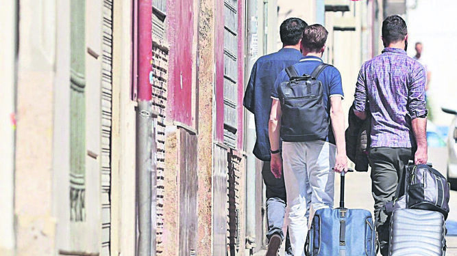 Turistas  con maletas buscando pisos turísticos
