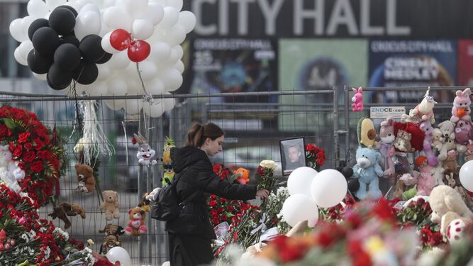 Una mujer deposita flores este lunes en Crocus City Hall, lugar del atentado en Moscú el pasado viernes.