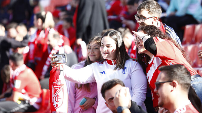 Unos jóvenes aficionados del Granada CF en la grada del Estadio Nuevo Los Cármenes.