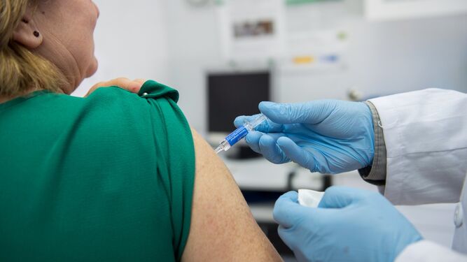 Una enfermera vacuna a una mujer en el brazo