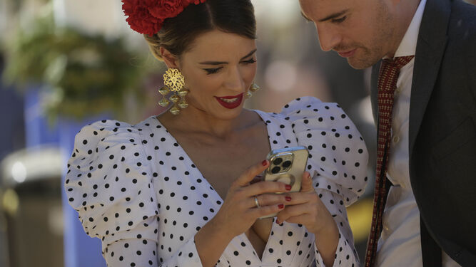Una flamenca consulta el móvil.