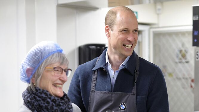 El príncipe de Gales sonríe con una voluntaria en su reaparición este jueves