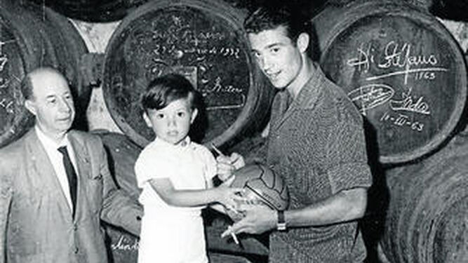 Isidro firma un balón a un niño en una bodega de Jerez en una visita con el Real Madrid.